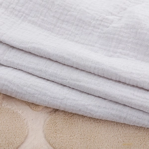 Close-up of soft grey muslin cotton fabric layers with breathable wrinkled texture