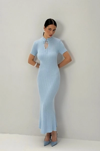 Dettaglio dell'abito in maglia azzurro con elegante collo a fiocco e vestibilità slim