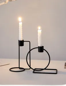 Detail of minimalist black metal geometric candle holder with white spiral candles