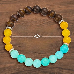 Three-color natural stone beads bracelet with silver spacers on dark wooden background