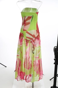 Détail d'une robe longue fleurie avec tissu vert, fleurs roses et ourlet en mousseline