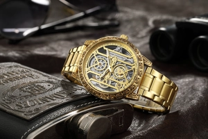 Détails d'une montre mécanique squelette dorée avec boîtier gravé et bracelet en acier