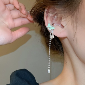 Détail du clip oreille papillon vert clair avec longue chaîne en argent et breloque zircon