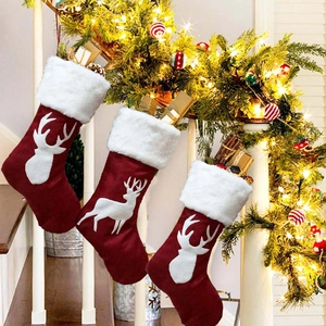 Vue détaillée de trois chaussettes de Noël rouges avec silhouette de renne et fausse fourrure