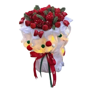Christmas bouquet with red roses, strawberries, LED lights and festive pom-pom wrapping