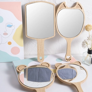 Minimalist wooden handheld mirrors in square and animal ear shapes on white background