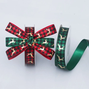 Detail of Christmas ribbon with gold foil reindeer on red and green plaid fabric