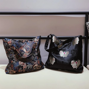 Detail of jacquard floral brocade and black satin butterfly embroidery on tote bags