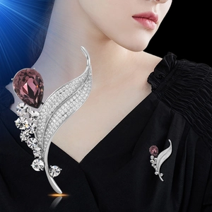 Leaf-shaped silver brooch with clear crystals and a large purple pear-cut gemstone