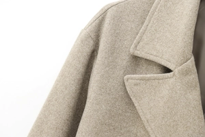 Dettaglio del bavero e delle cuciture premium sul cappotto di lana beige