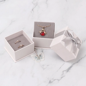 Elegant jewelry gift box with bow featuring a red heart necklace and sparkling rings