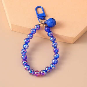 Detail of blue iridescent beads and silver bell charm for keychain and bag accessory
