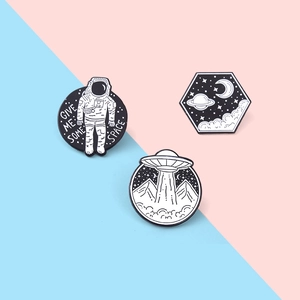 Lot de trois pin's sur l'espace avec astronautes et OVNI sur un fond pastel bicolore