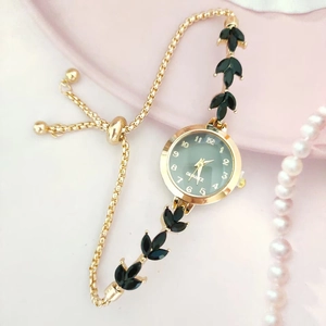 Gros plan sur la montre quartz dorée avec cadran vert et bracelet à bijoux feuilles