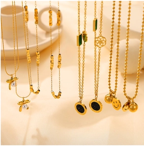 Detail view of assorted gold plated stainless steel necklaces with various trendy charms