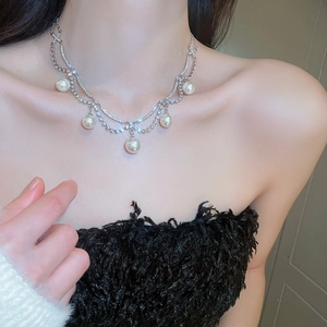 Close-up of double-layer silver necklace with five large pearls and sparkling rhinestones
