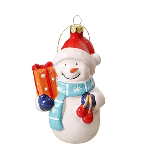 Festive snowman Christmas tree ornament with red hat and scarf holding a gift box