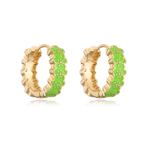 Macro shot of gold-plated hoop earrings with green enamel and white floral pattern