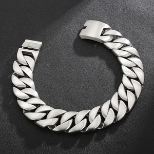 Detail of silver heavy Cuban link chain with secure fold-over clasp on dark surface