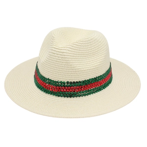 Chapeau de paille Panama avec ruban vert et rouge orné de strass sur fond crème