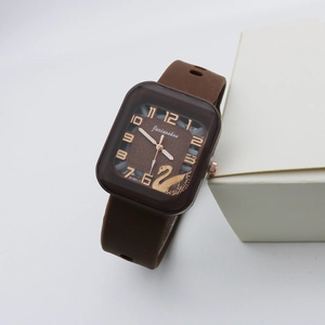 Close-up of square quartz watch with rose gold swan motif and brown silicone strap