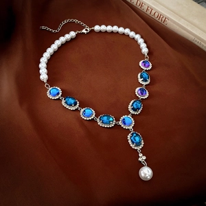 Macro detail of luxury silver necklace with pearls and purple gemstone pendant details
