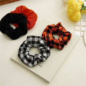 Set of 4 pumpkin orange and black scrunchies in plaid and pleated fabric for hair styling