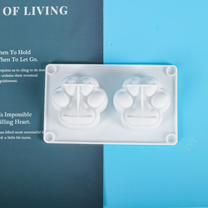 Detailed top view of 2-cavity cat paw silicone mold for DIY crafts on a dual-tone background