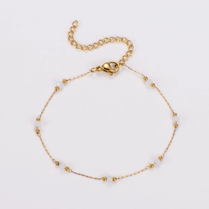 Detail of gold beaded chain bracelet with white pearls and adjustable lobster clasp