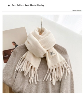 Detail of off-white cashmere-like scarf with fringe and brand label on a coat hanger