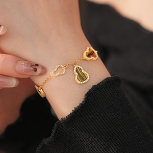Macro shot of 18K gold plated Wulu charms bracelet with zircon and tiger eye stones
