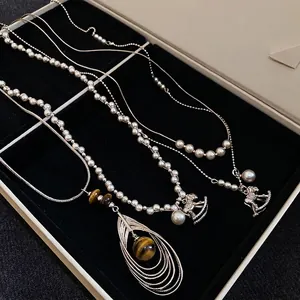 Vintage zircon pearl horse necklaces and tiger eye stone pendant in a jewelry box
