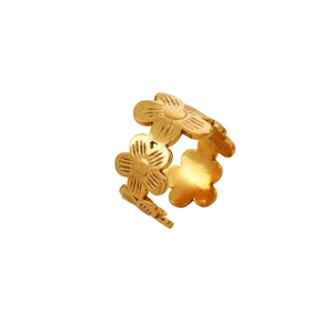 Macro detail of gold-plated daisy hollow band ring with fine petal texture and open design