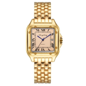 Detail of square gold watch face with blue hands, Roman numerals and calendar window
