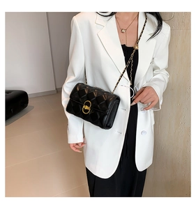 Chic black quilted shoulder bag with gold chain strap shown on a model in a modern room