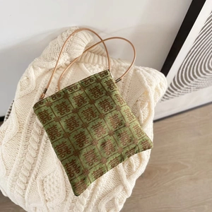 Close-up of 6mm green fabric strap on bag with red double happiness xi pattern