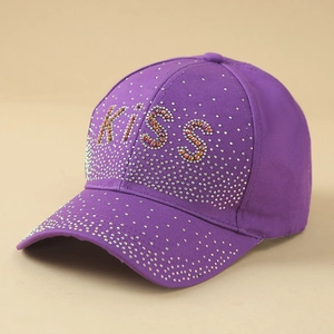 Detail of purple baseball cap featuring a sparkling KISS rhinestone letter pattern decoration