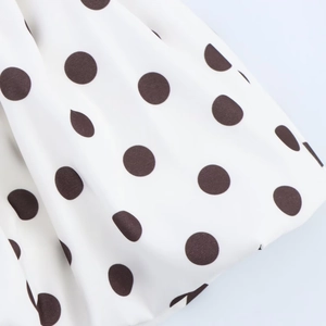 Gros plan du tissu de robe blanc avec de gros pois noirs et une texture raffinée
