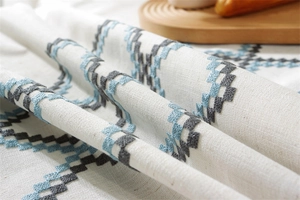 Close-up of geometric cross-stitch embroidery on waterproof linen tablecloth fabric