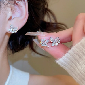Close-up of elegant butterfly stud earrings with zircon crystals on a silver base