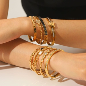 Gold-plated stainless steel bracelet set featuring heart charms and zircon stones on model