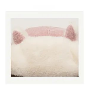 Detail of pink knitted winter hat with soft white faux fur trim and cute cat ears