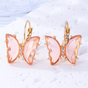 Close-up of pink crystal butterfly drop earrings with gold metal edges and white rhinestones