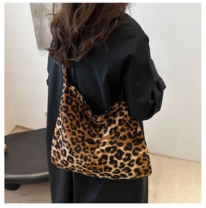 Detail of leopard print tote bag in soft plush fabric carried by a model on shoulder