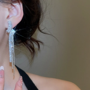 Orecchini a nappa in argento con zirconi indossati da una modella di profilo