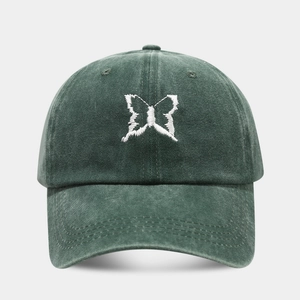 Dark green washed cotton baseball cap with white butterfly embroidery on a curved brim