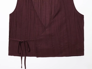Detailed close-up of dark burgundy crinkle texture vest with wrap-around tie closure