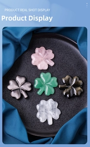 Polished natural crystal four-leaf clover carvings in five colors on a black tray