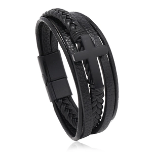 Detailed view of multilayer black braided leather bracelet with central cross and magnetic clasp