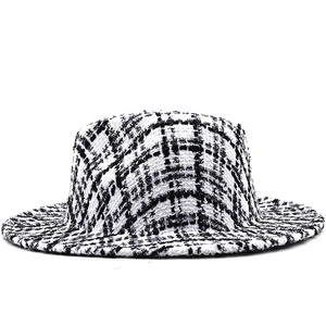 Close-up of black and white houndstooth tweed texture on a classic retro style fedora hat